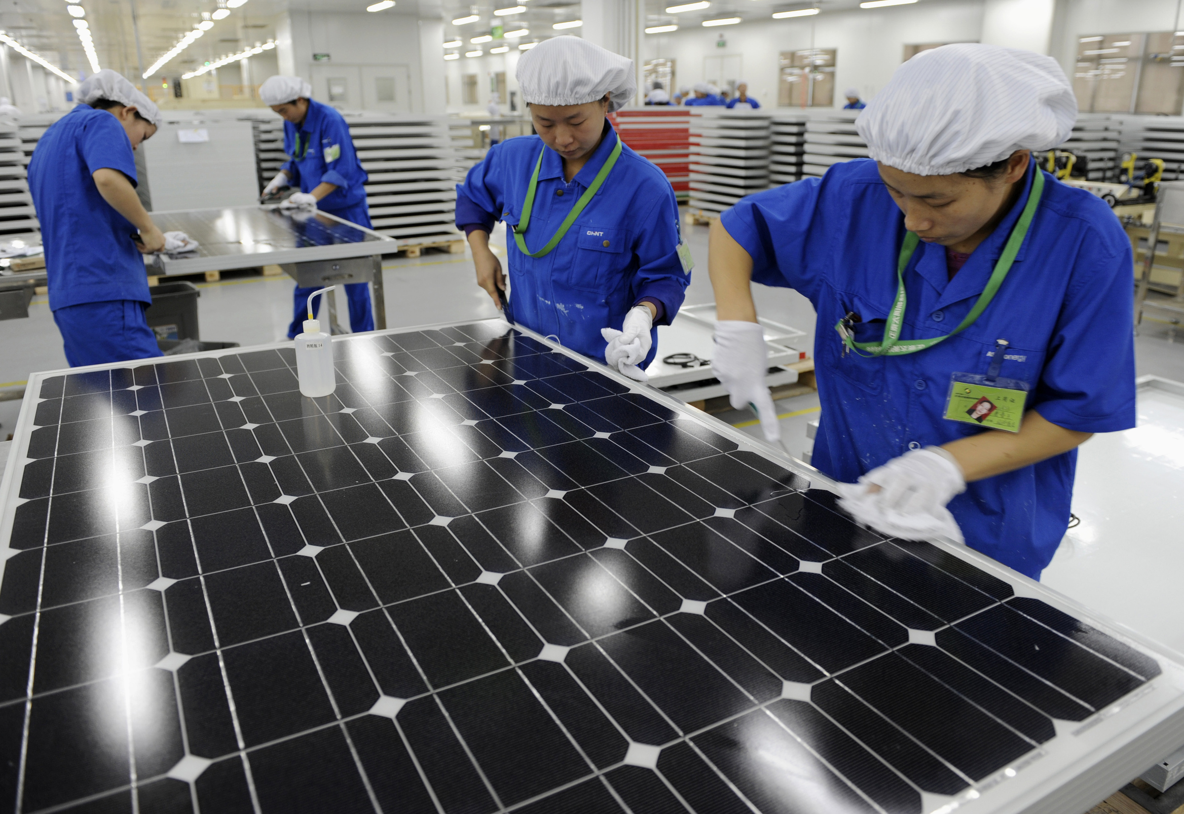 Nhân viên kiểm tra các tấm pin mặt trời tại nhà máy ở Hàng Châu, Chiết Giang. Ảnh: Reuters