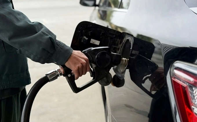 Nhân viên cây xăng bơm nhiên liệu cho khách. Ảnh: DMS