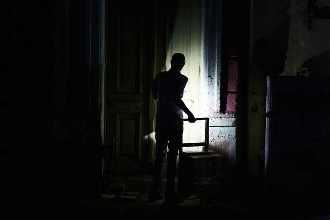 Người đàn ông đi vào một tòa nhà trong cảnh mất điện ở Havana, Cuba ngày 16/3. Ảnh: AP